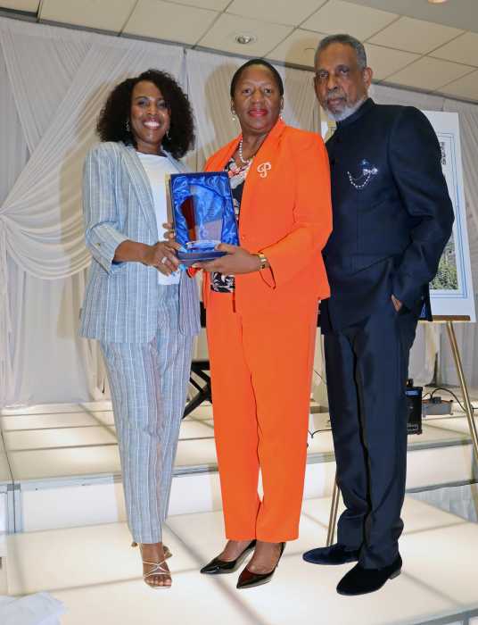 Karen Moodie, CDU member, left, presents plaque to Trinidad and Tobago Opposition Leader Pennelope Beckles-Robinson, flanked by former Grenada Amb. Eugene Pursoo.